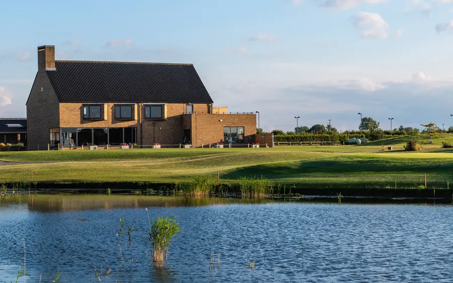 The clubhouse across the lake under a blue sky