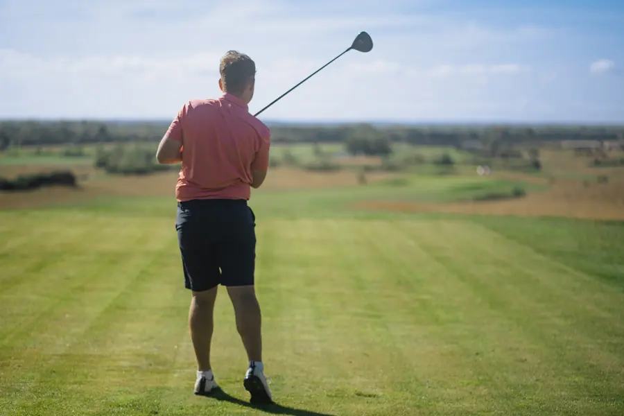 A golfer on the tee from behind, driver on the shoulder