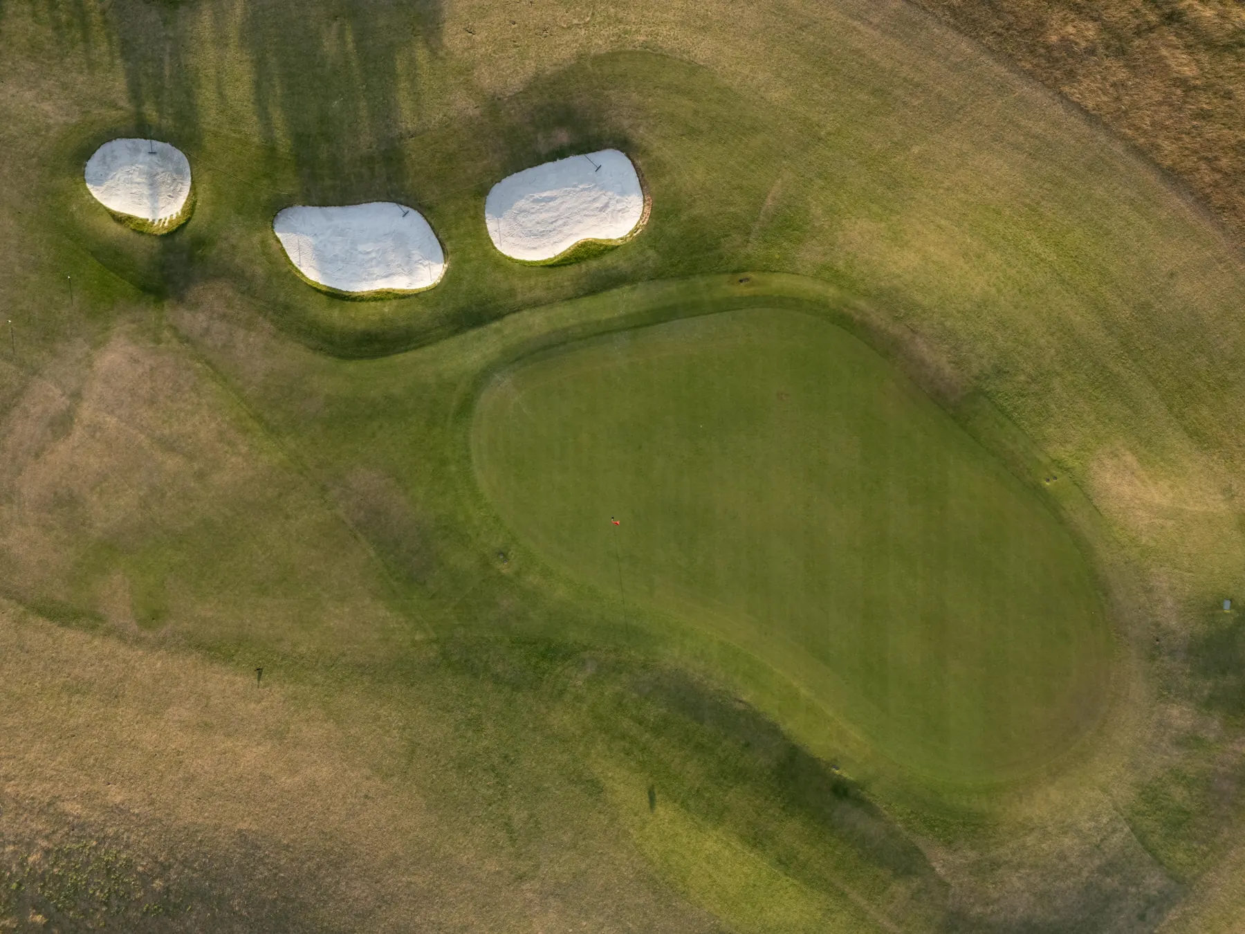 A green and three bunkers seen from directly above