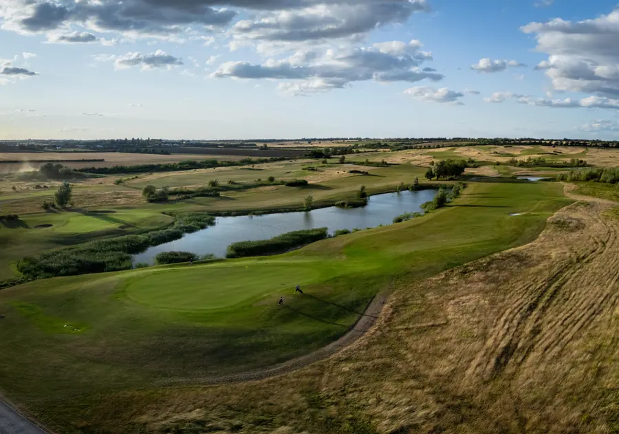A lake along a fairway from the air, evening light