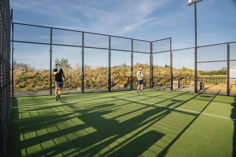 Padel doubles in long evening shadows