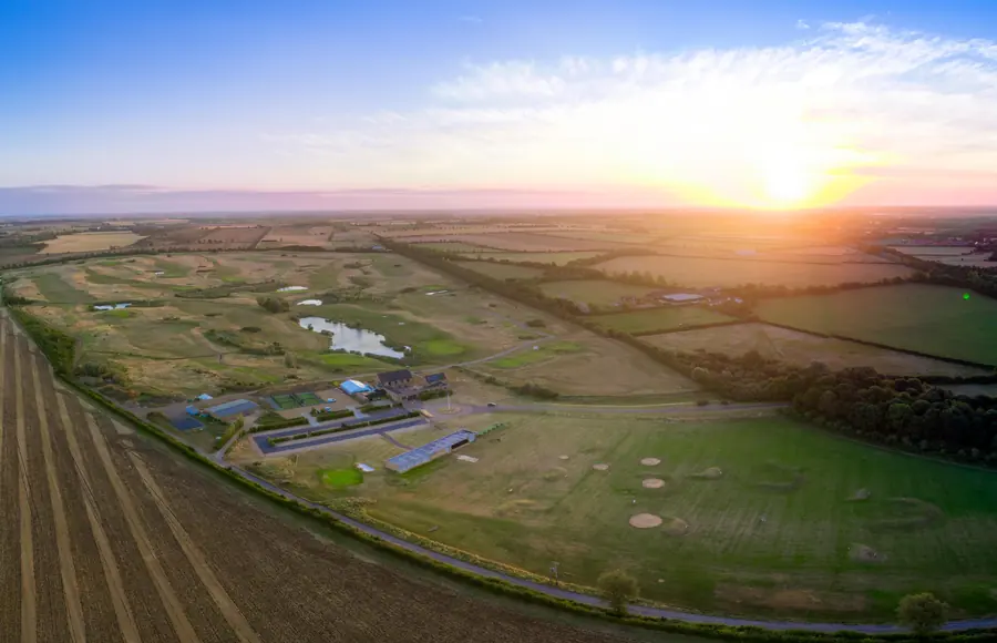 Sunrise over the course and the clubhouse, from the air